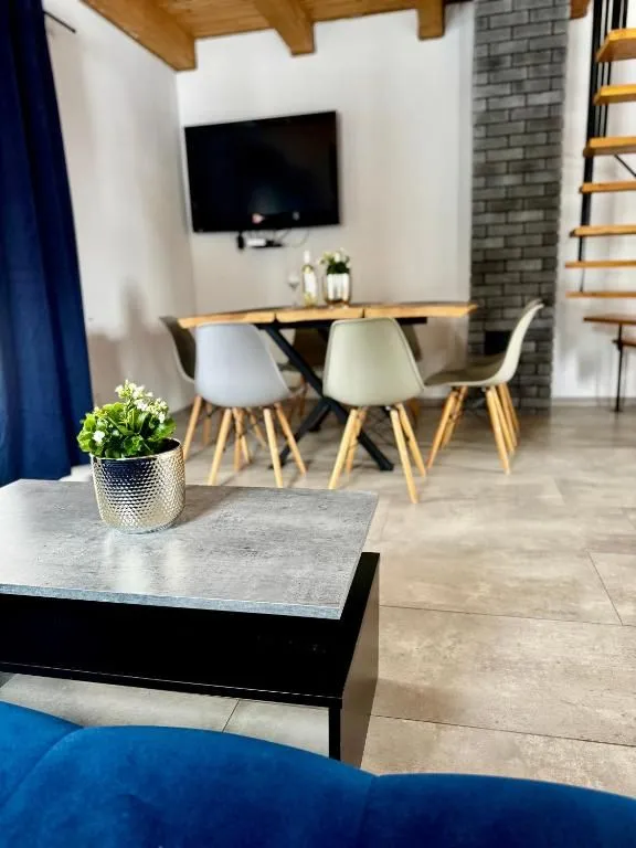 Stół jadalniany z krzesłami i telewizor na ścianie salonu